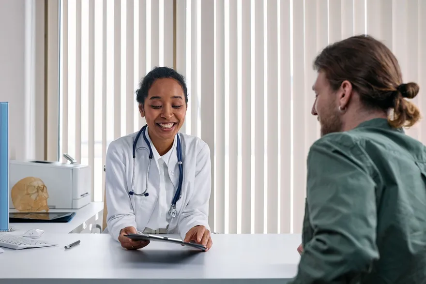 A clinician talking with a patient across a desk