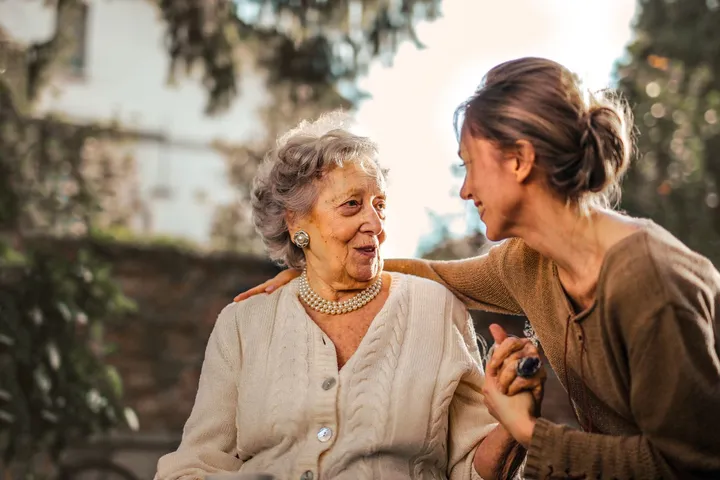 An older patient sharing a warm, reassured moment at home