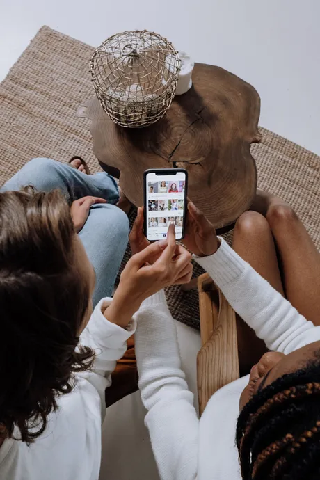 Two people at home watching a video on a phone
